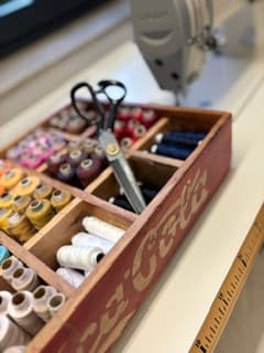 Schneiderschere im Nähkasten neben der Nähmaschine